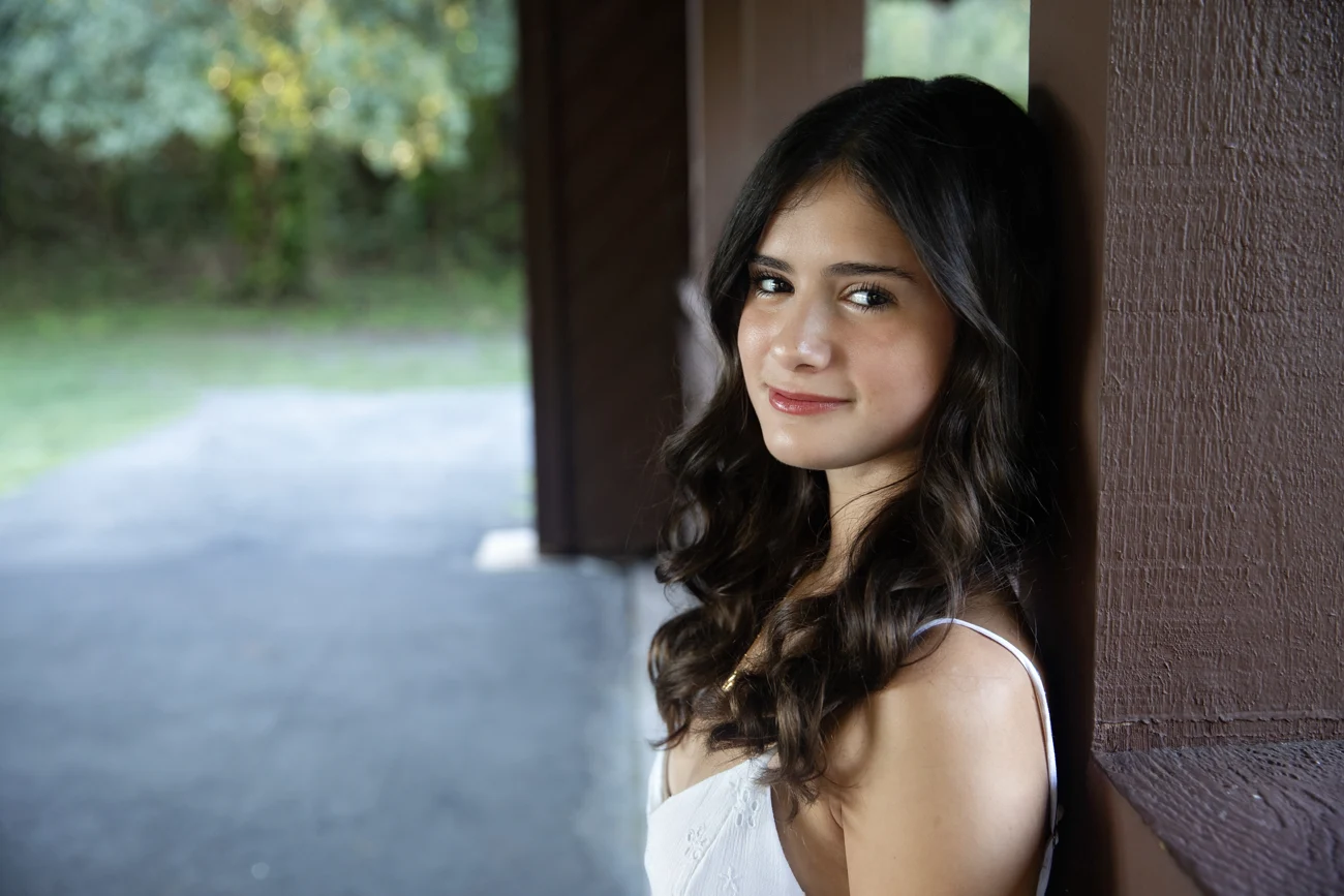 Ariana Ehrenthal smiling, standing beside a window.
